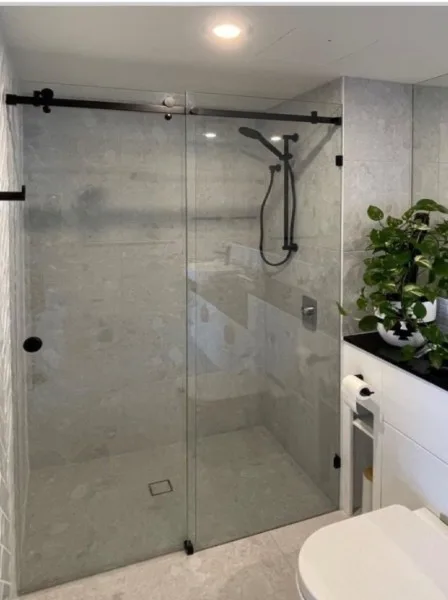 Frameless sliding shower screen with matte black rail