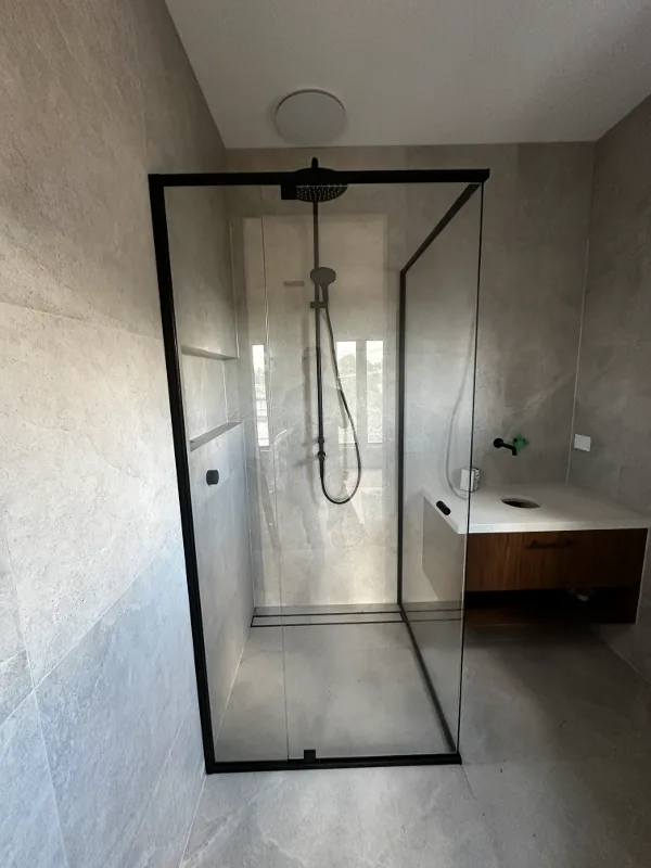 Semi-frameless corner shower screen with matte black frame