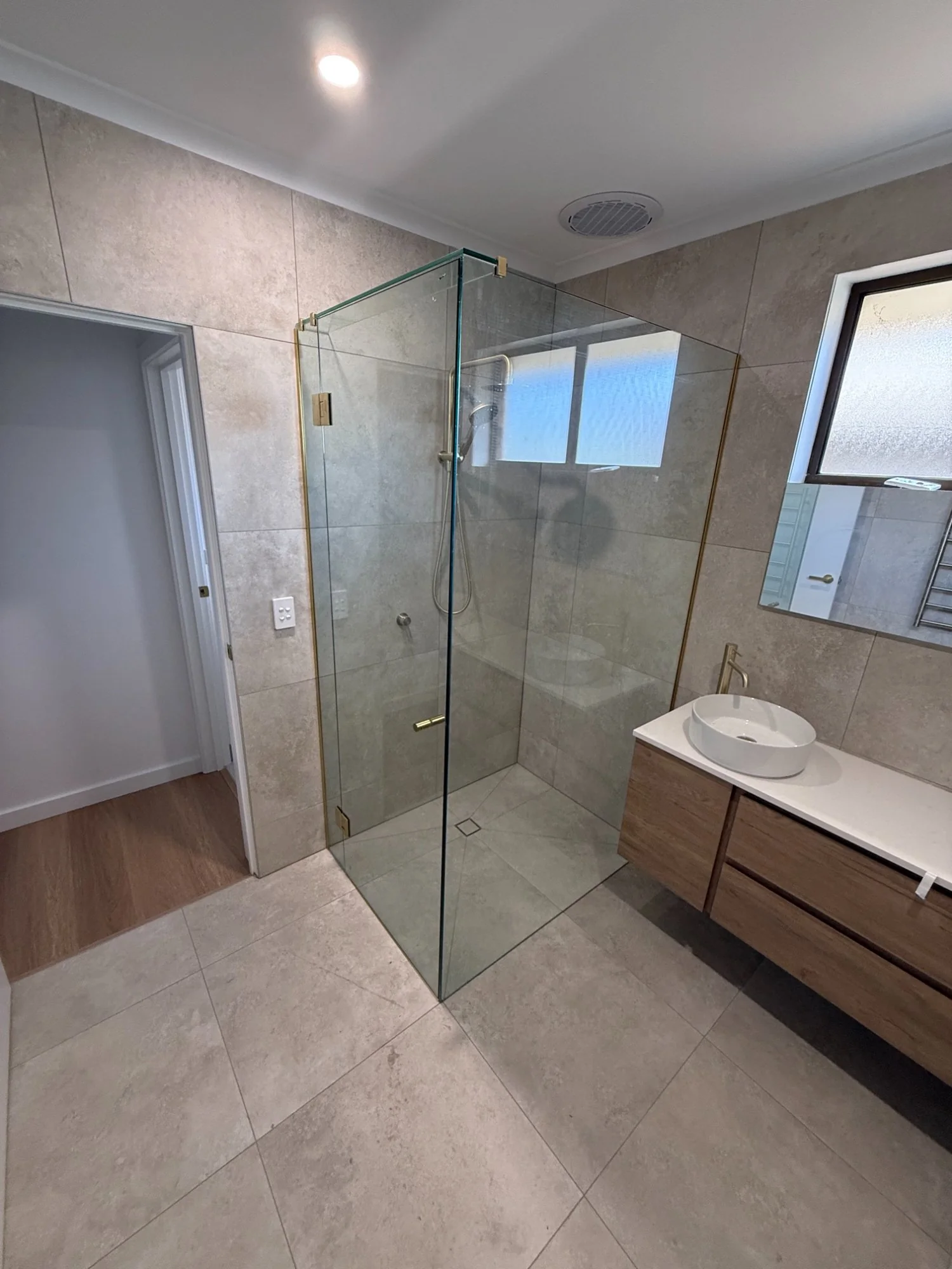 Frameless shower screen with brushed gold hardware Melbourne